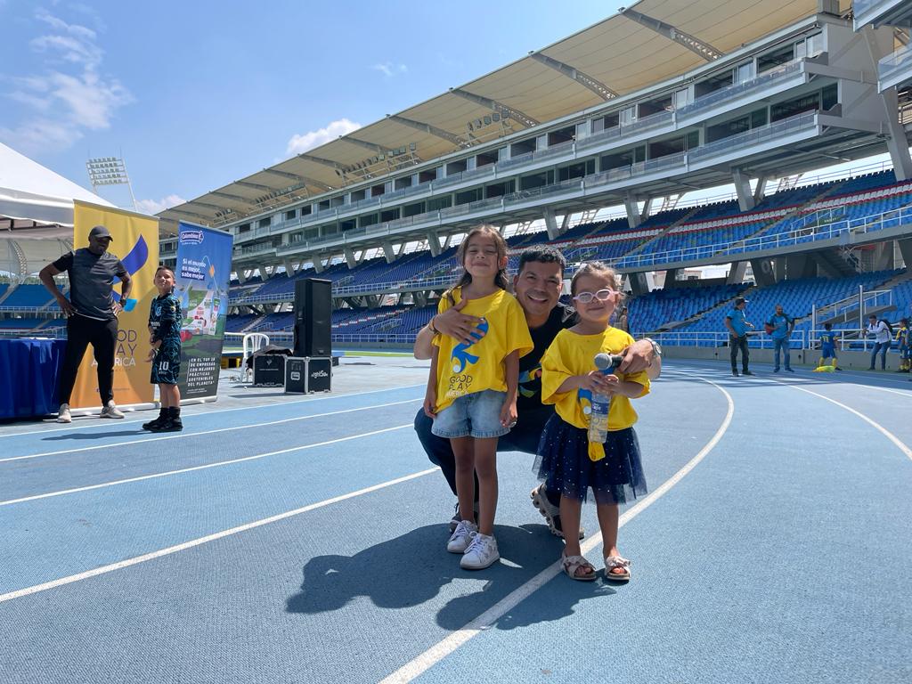 Alejandro Henao, fundador y presidente de Good Play America, junto a dos niñas beneficiarias. 
